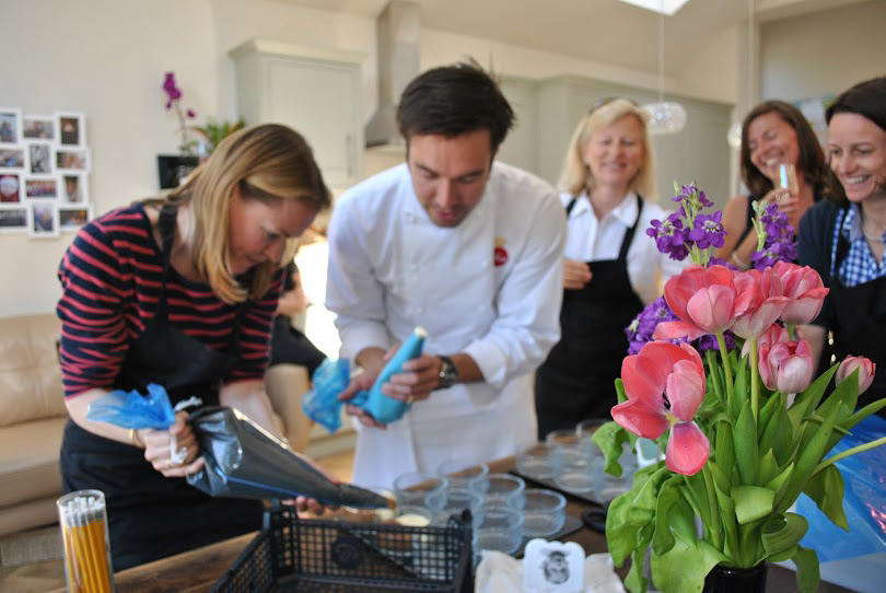 Gregory helping a home cook pipe ingredients while others watch.