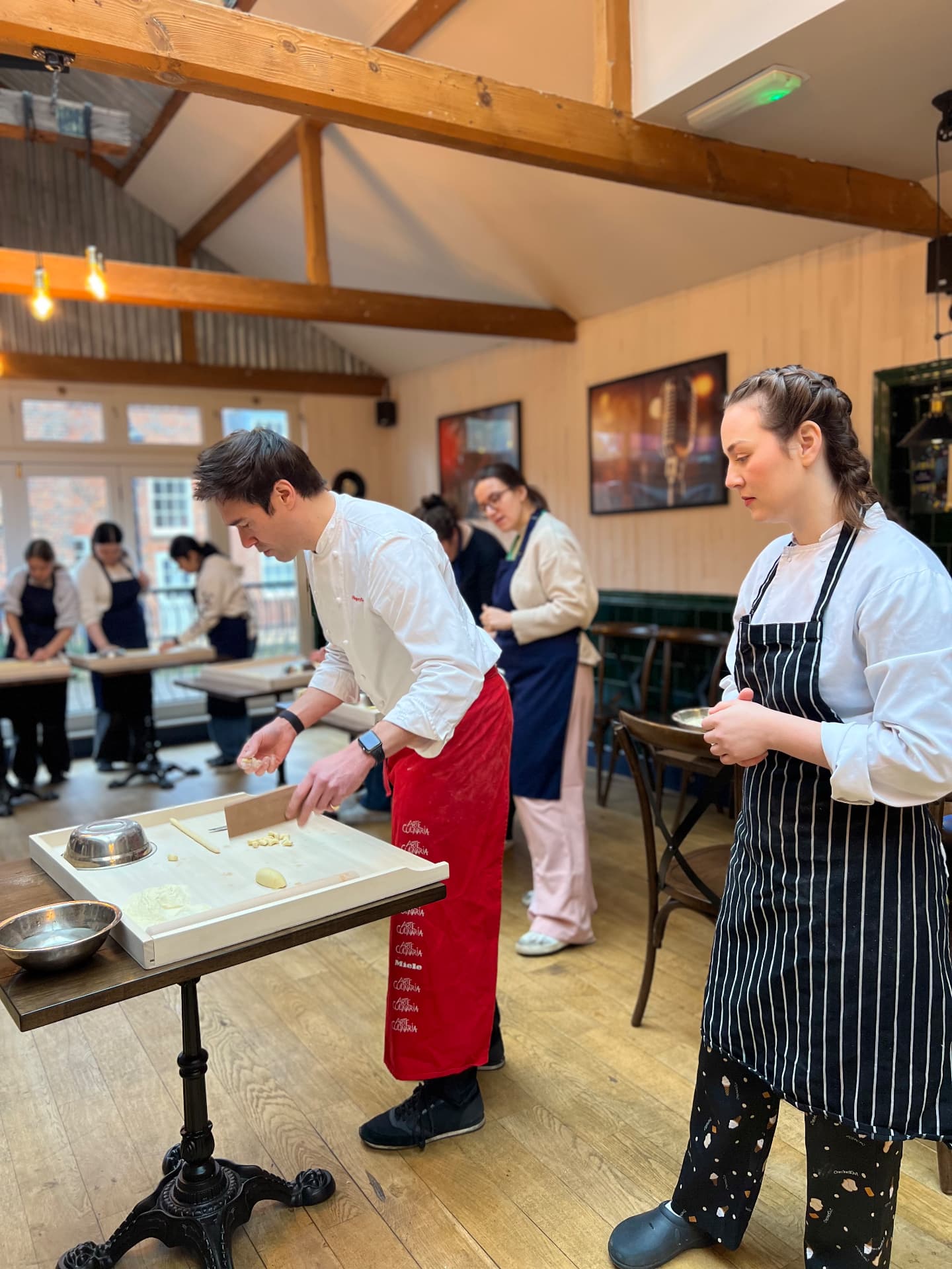 Gregory demonstrating a cooking technique to a small group.