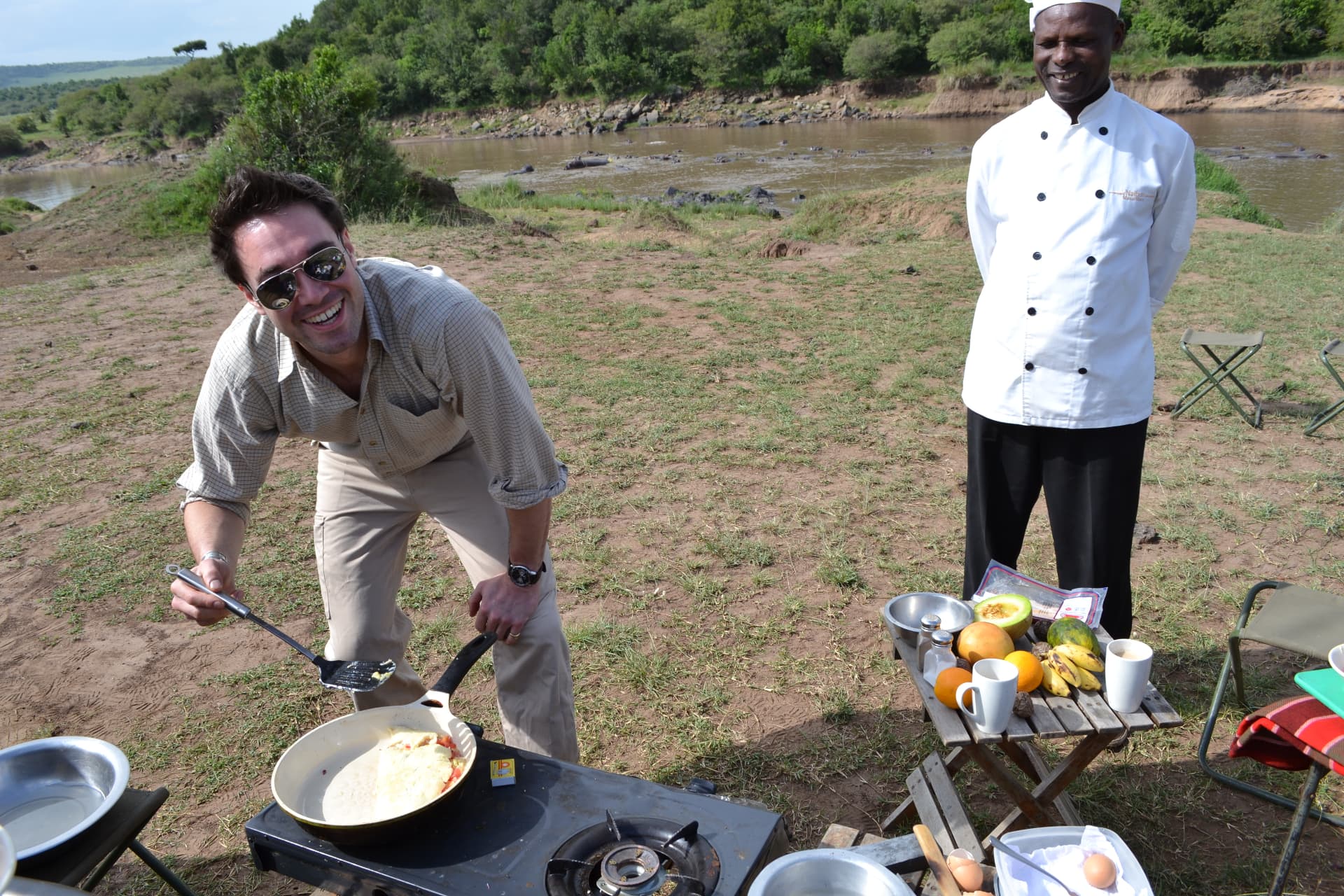 Gregory cooking over an open fire on safari in Kenya.