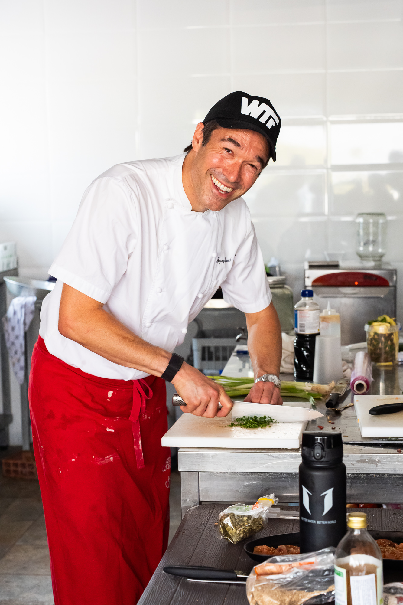 Gregory at the pass in chef whites, working through a dish.