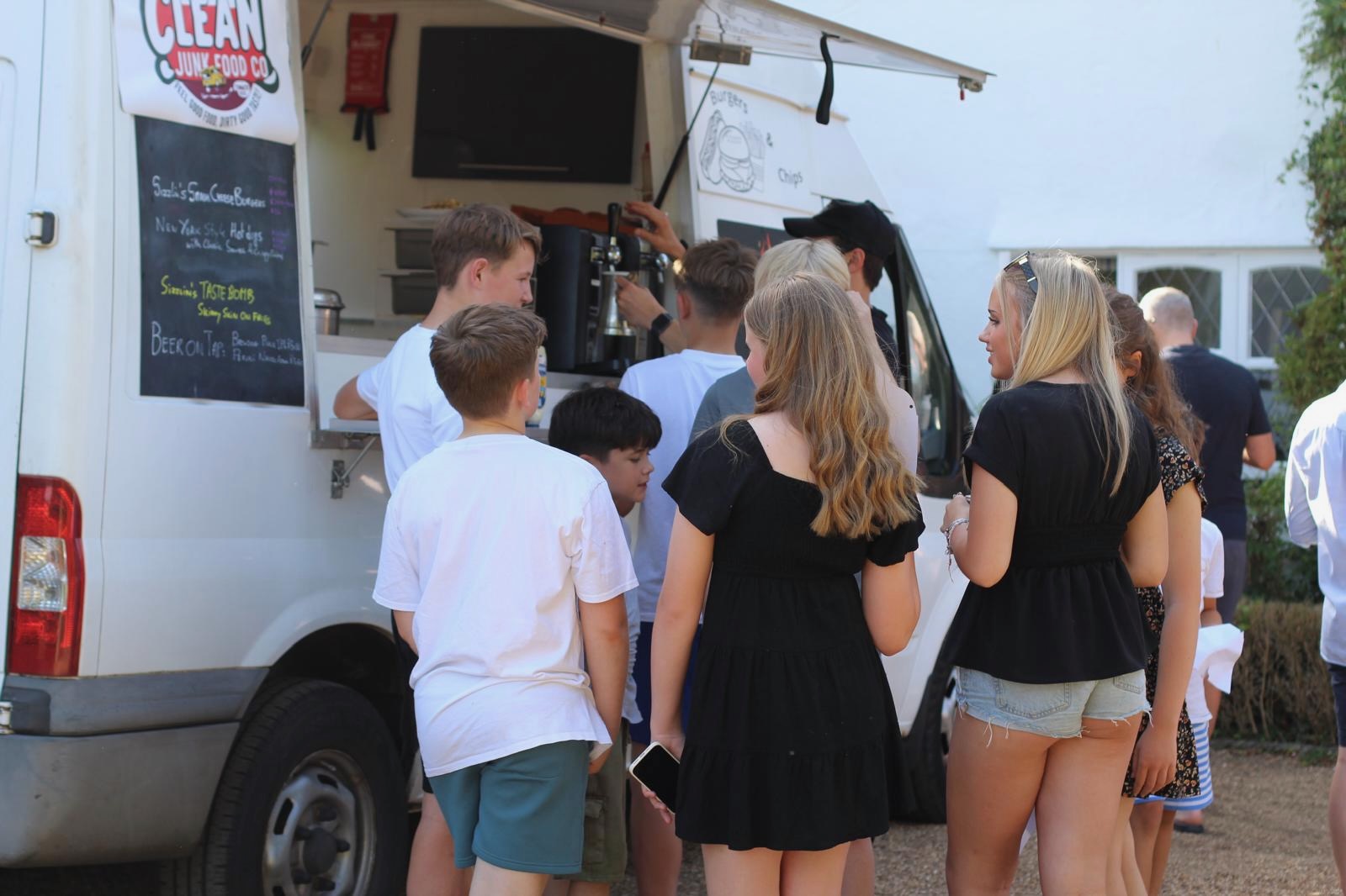 Guests gathering at the Clean Junk Food Co. truck hatch.