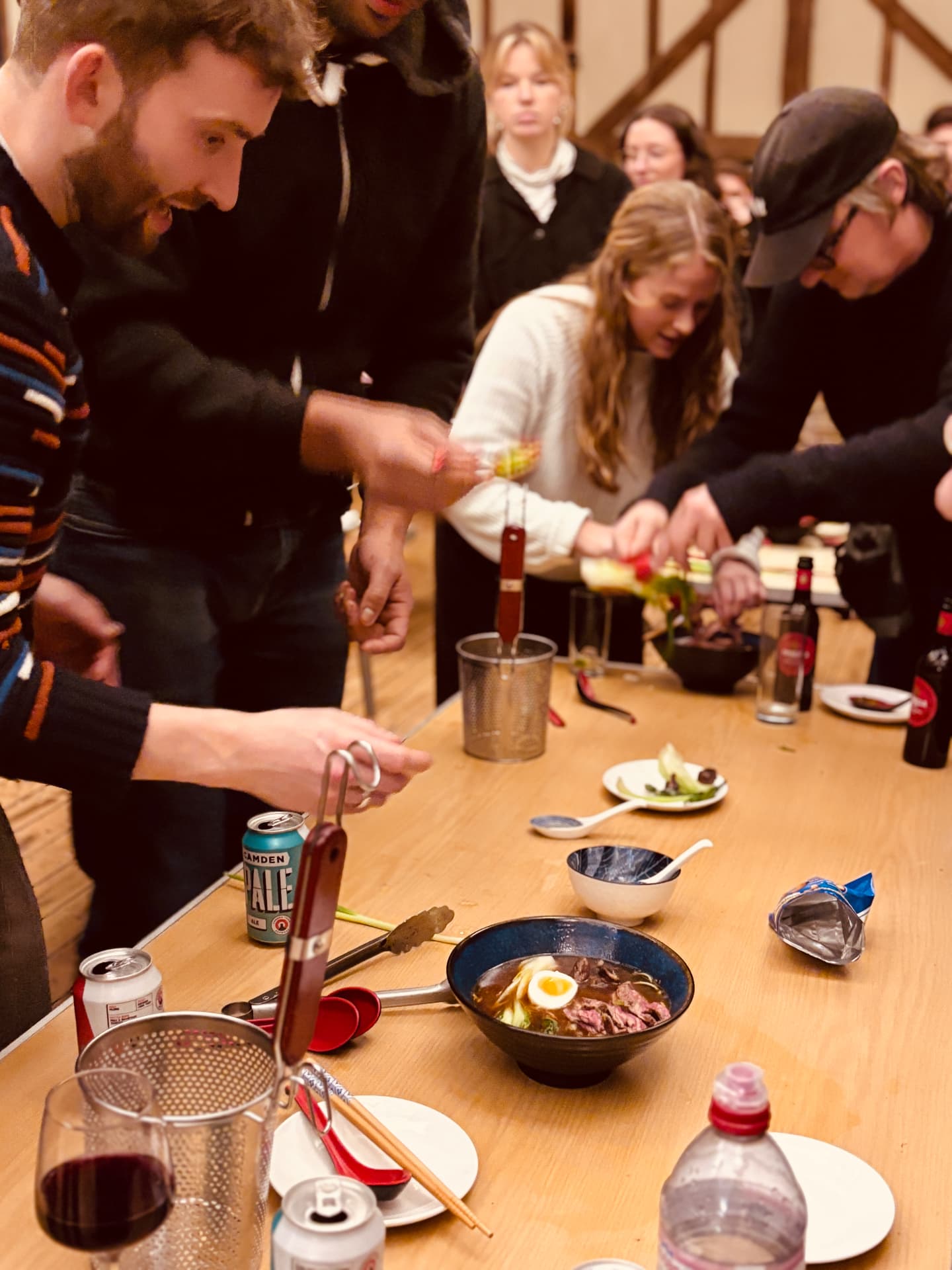 Participants cooking together around a long table at a workshop.