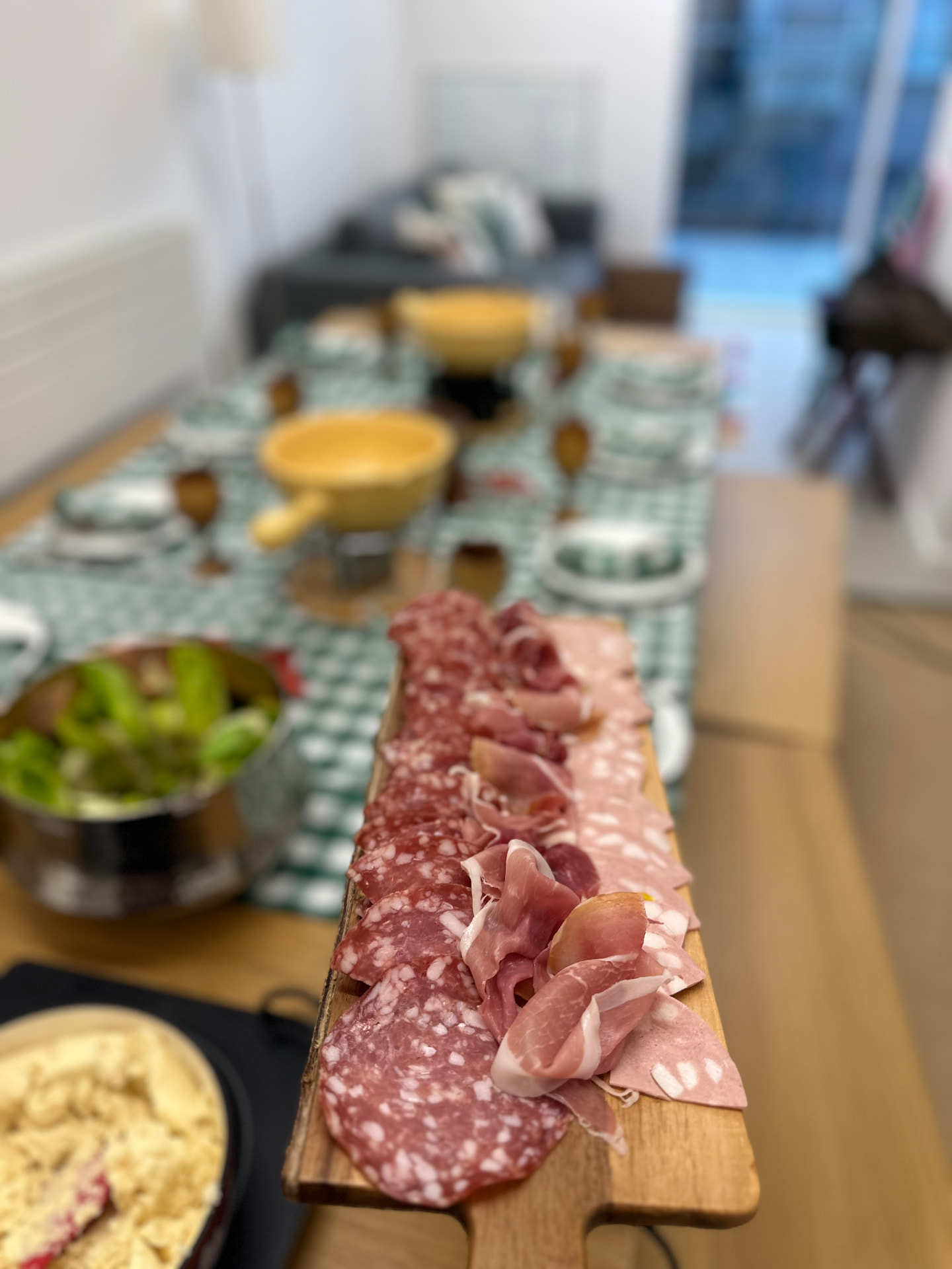 An Alpine charcuterie board beside a fondue table.