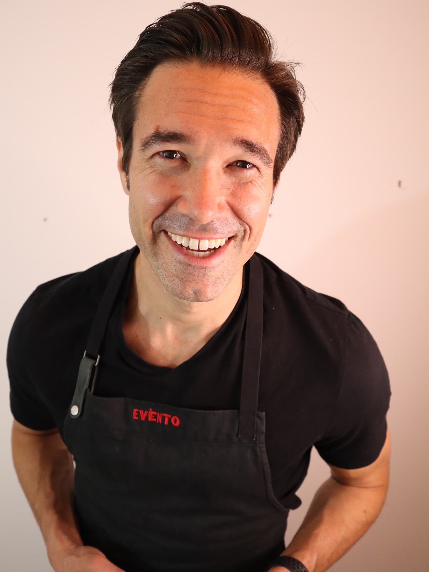 Gregory laughing in his black Evento apron.