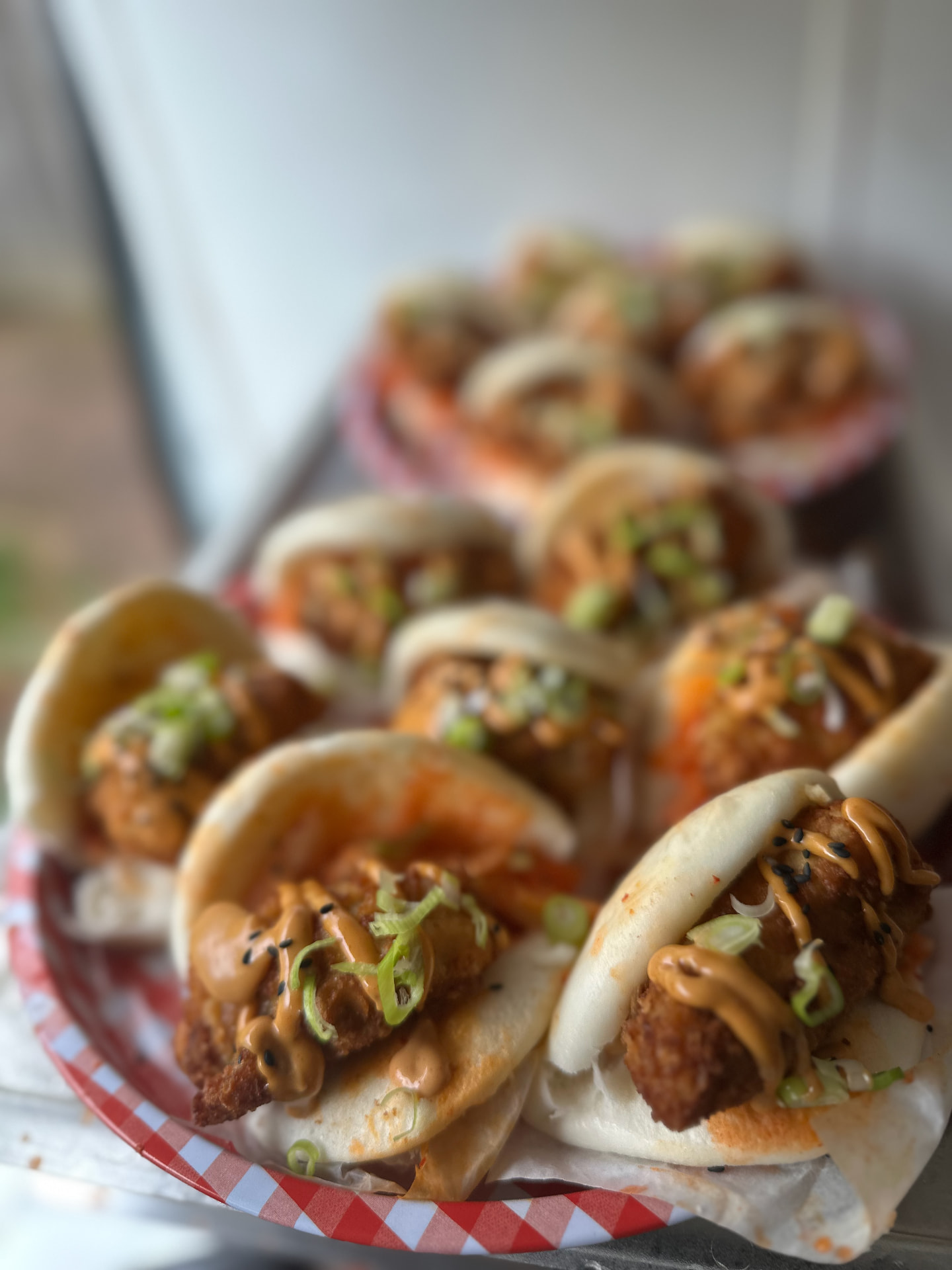 A generous tray of crisp chicken bao buns with spring onion and sauce.