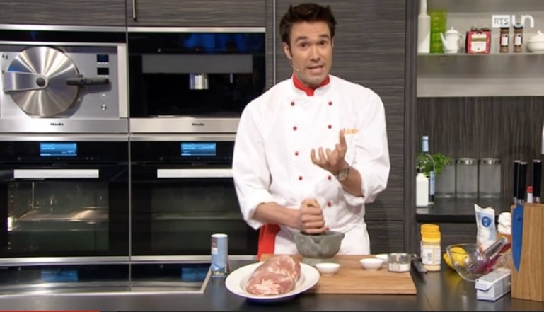 Gregory explaining a dish to camera in a television kitchen.