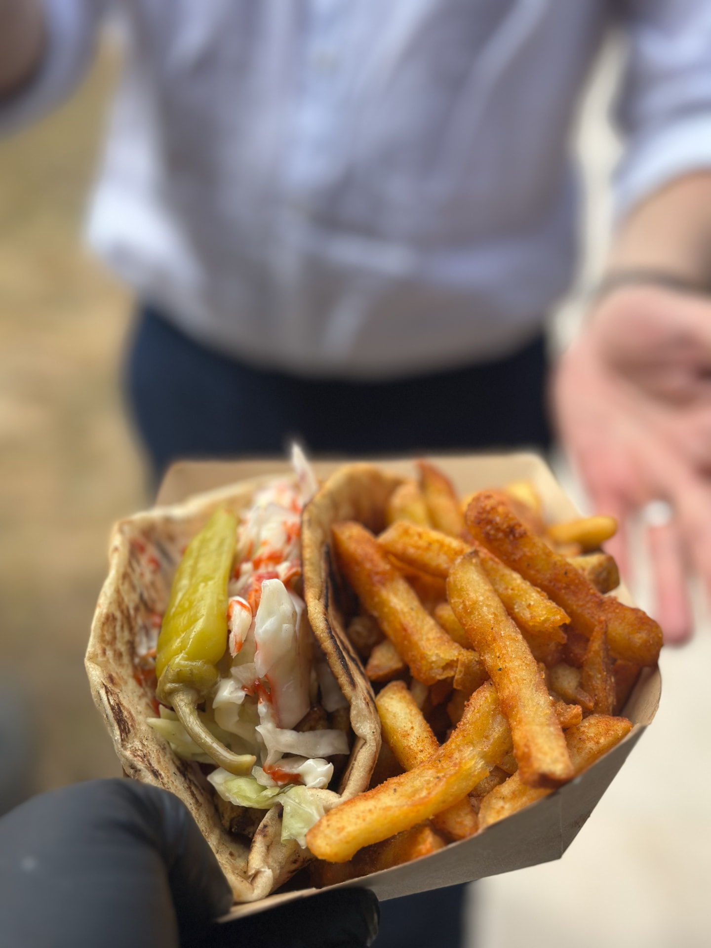A loaded flatbread with green pepper and seasoned fries.