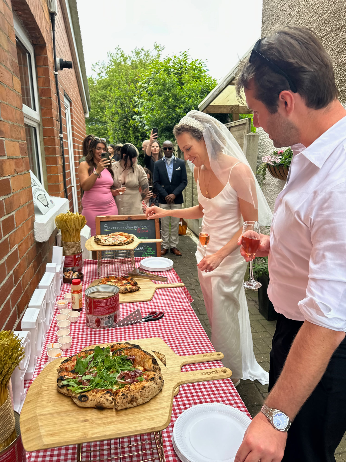 A bride and groom choosing sourdough pizzas at their wedding celebration.