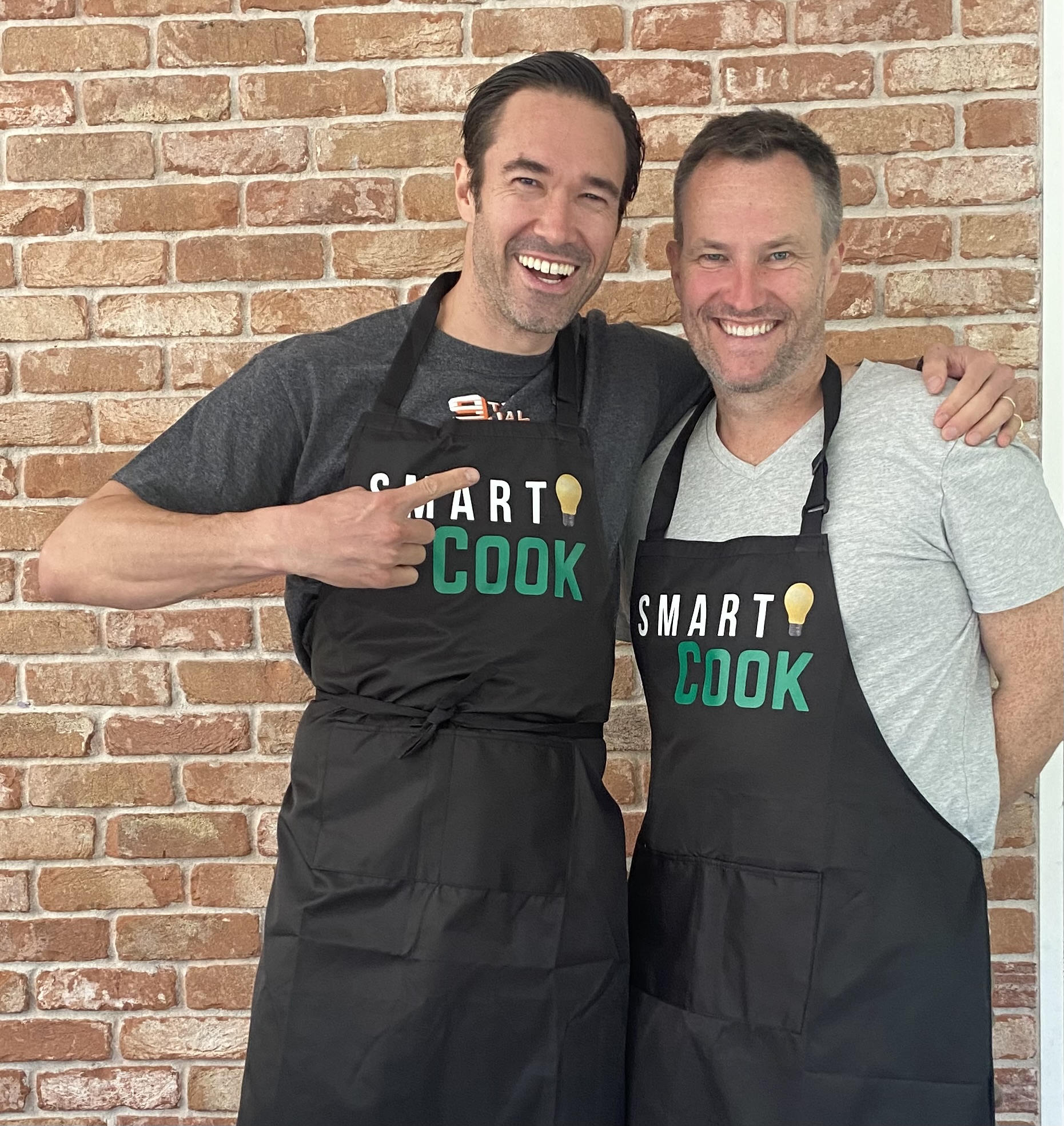 Gregory and a fellow cook laughing in Smart Cook aprons.